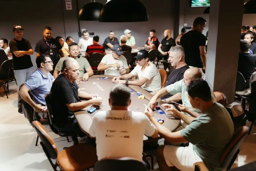 Spelers aan een pokertafel tijdens een live pokertoernooi met chips en kaarten op tafel