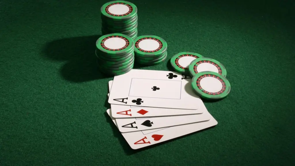 Casinochips en speelkaarten op een groene tafel.