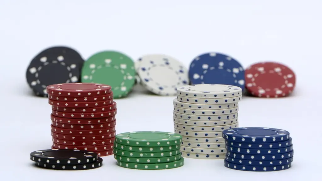 Diverse kleuren pokerchips gestapeld op een witte achtergrond
