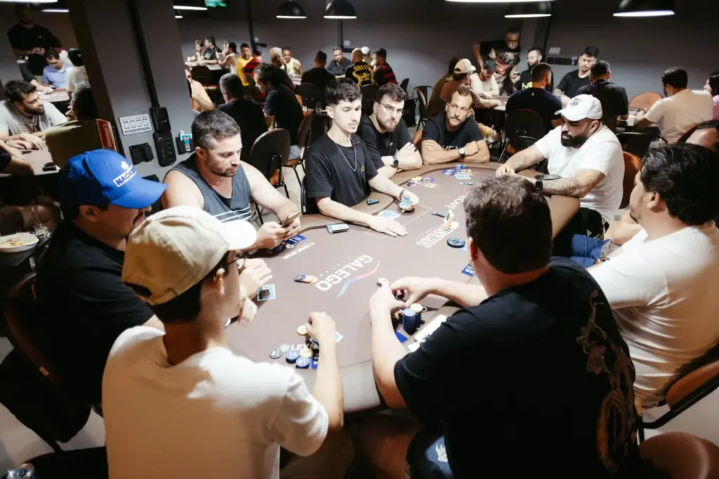 Spelers aan een volle pokertafel tijdens een live pokertoernooi met chips op tafel